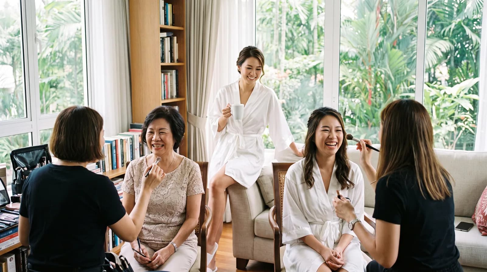 A bride's mother and sister having their makeup done at the same time in a bright living room